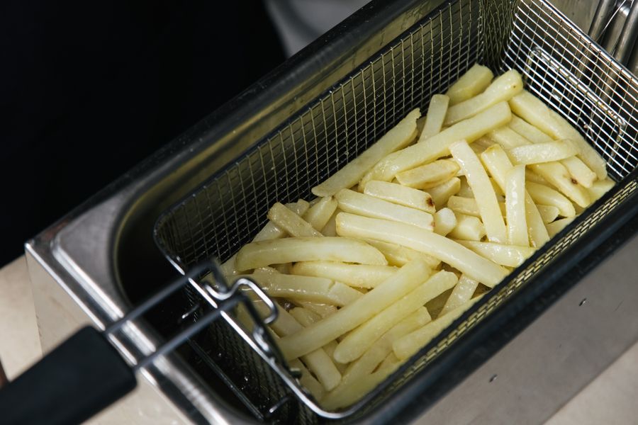 Papas fritas crudas en freidora tradicional